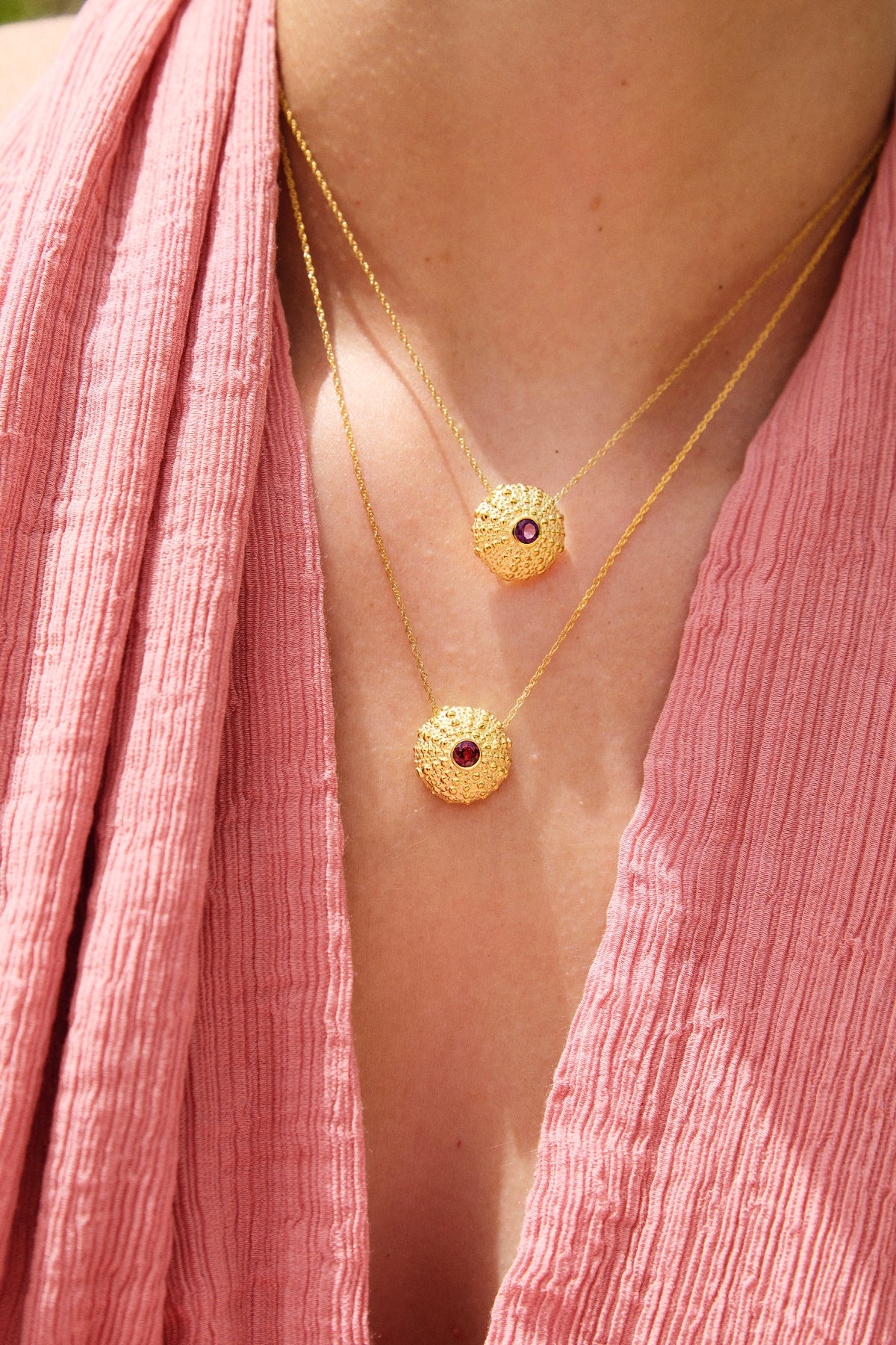 Feggeri Ahinos gemstone necklaces in gold vermeil layered over a pink dress