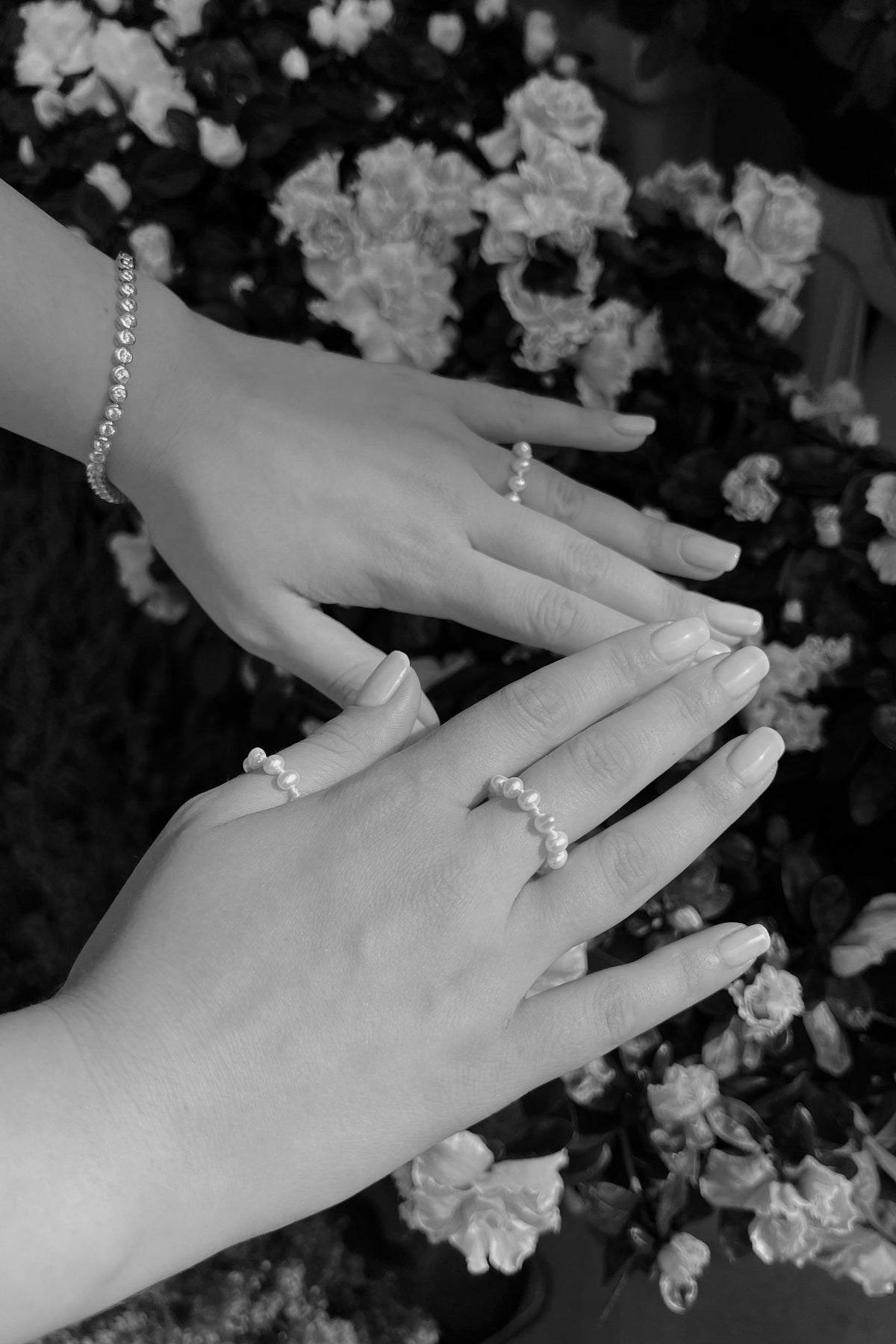 Feggeri Aphrodite pearl rings worn on the hands, photographed in black and white
