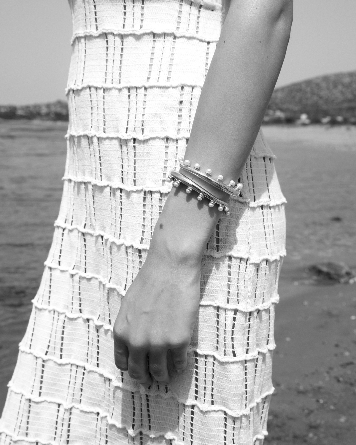 Feggeri Okto pearl cuff worn with a fringed dress, photographed in black and white