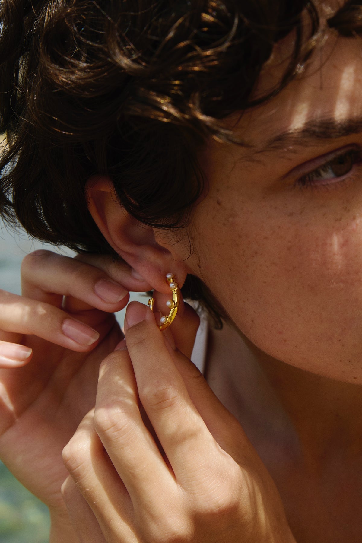 Feggeri Okto pearl hoop earring in gold vermeil being put on